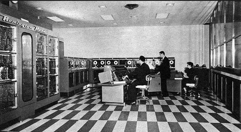 Vista general de la instalación del UNIVAC  A la izquierda tenemos a Mauchly a los mandos del UNIVAC junto a dos operarios de la máquina.